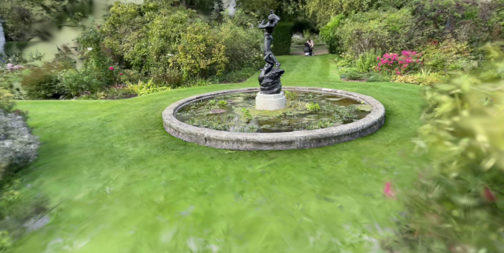 A garden with a fountain reconstructed as a 3D Gaussian Splat, showing the soft volumetric look of the technique